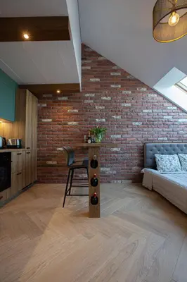 a living room with a couch and a brick wall at M8 Exclusive Studio Apartment in Kaunas