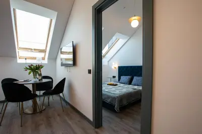 a mirror in a room with a bed and a table at M8 Stylish One-Bedroom Apartment in Kaunas
