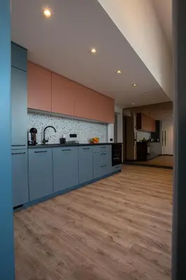 an empty kitchen with blue cabinets and a wooden floor at M8 Stylish One-Bedroom Apartment in Kaunas