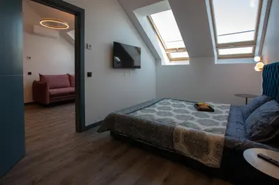 a bedroom with a bed and a couch and a mirror at M8 Stylish One-Bedroom Apartment in Kaunas