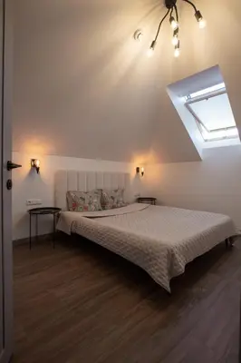 a bedroom with a large bed with a window at M8 Modern Two-Floor Apartment in Kaunas