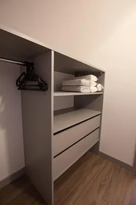 a closet with white drawers and towels in it at M8 Modern Two-Floor Apartment in Kaunas