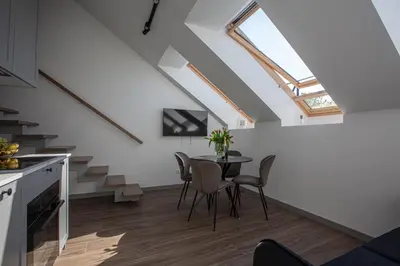 a kitchen and dining room with a table and a skylight at M8 Modern Two-Floor Apartment in Kaunas