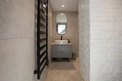 a bathroom with a sink and a white brick wall at M8 Modern Two-Floor Apartment in Kaunas
