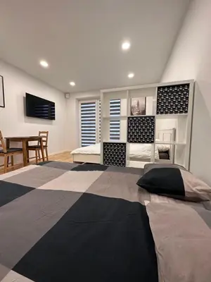 a bedroom with a large bed and a dining room at OZO Life Apartment in Vilnius