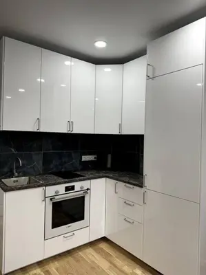 a white kitchen with white cabinets and a refrigerator at OZO Life Apartment in Vilnius
