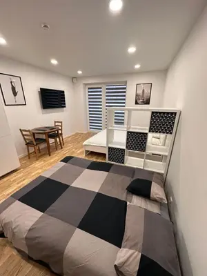 a bedroom with a large bed and a table at OZO Life Apartment in Vilnius