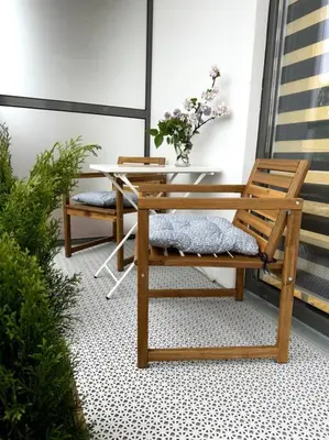 a patio with a bench and a table with flowers at OZO Life Apartment in Vilnius