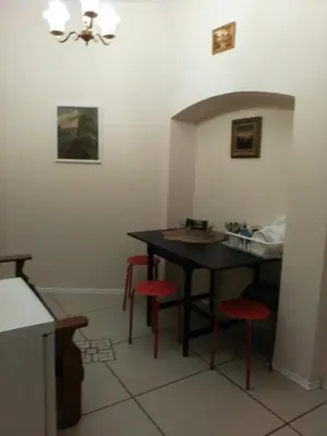 a kitchen with a black table and red stools at Dora Apartment Užupis in Vilnius