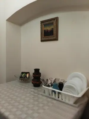 a room with a table with dishes and a picture on the wall at Dora Apartment Užupis in Vilnius