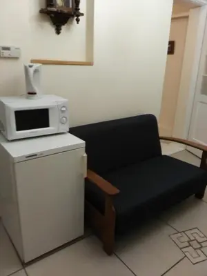 a chair sitting in a room with a microwave at Dora Apartment Užupis in Vilnius