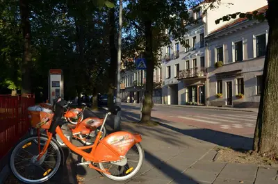 an orange motorcycle parked on a sidewalk next to a street at Dora Apartment Užupis in Vilnius