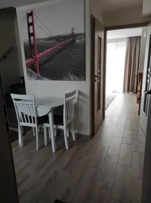 a dining room with a table and chairs and a picture of a bridge at Apartamentai G&G in Jurbarkas