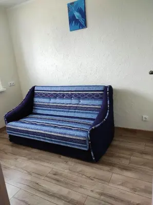 a couch sitting on the floor in a room at Apartamentai G&G in Jurbarkas