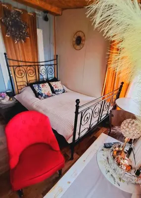 a bedroom with a bed and a red chair at DAGNA summer house in Šunupis