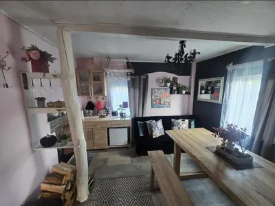a living room with a table and a kitchen at DAGNA summer house in Šunupis