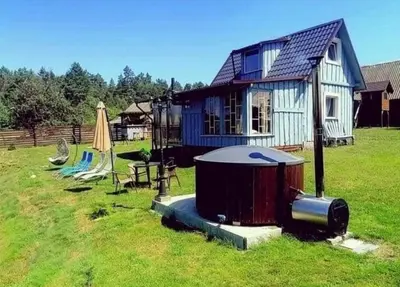 a small house with a hot tub and a playground at DAGNA summer house in Šunupis