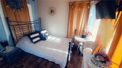 a bedroom with a bed and a table and a window at DAGNA summer house in Šunupis