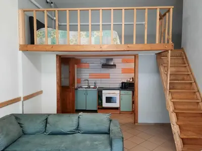 a loft bed in a living room with a couch at Spacy apartment in Kaunas center in Kaunas