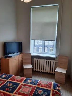 a bedroom with a bed and a tv and a window at Spacy apartment in Kaunas center in Kaunas