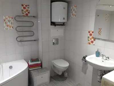 a white bathroom with a toilet and a sink at Spacy apartment in Kaunas center in Kaunas