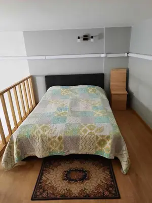 a bed with a quilt on it in a bedroom at Spacy apartment in Kaunas center in Kaunas