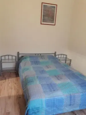 a bed with a blue comforter in a room at Spacy apartment in Kaunas center in Kaunas