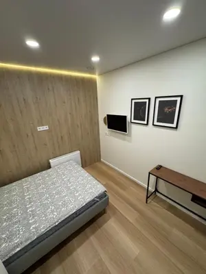 a bedroom with a bed and a table at 14 New Airport Apartment in Vilnius