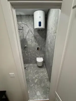 a small bathroom with a toilet and a water tank at 14 New Airport Apartment in Vilnius