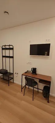 a desk and a chair in a room with a wall at 14 New Airport Apartment in Vilnius