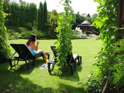 a woman sitting in a chair in a yard at Bellavilla in Vilnius