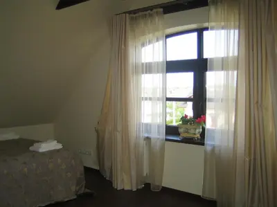 a bedroom with a window with curtains and a bed at Bellavilla in Vilnius