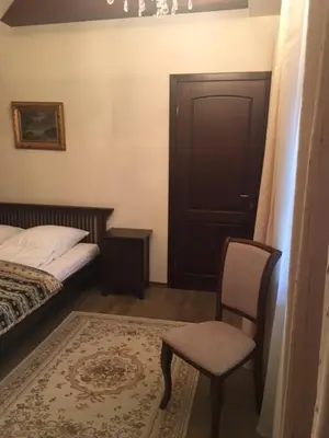 a bedroom with a bed and a chair and a door at Bellavilla in Vilnius
