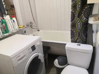 a bathroom with a washing machine and a toilet at Kambario nuoma namelyje in Kaunas