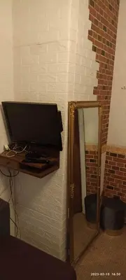 a flat screen tv on a wall next to a mirror at Kambario nuoma namelyje in Kaunas