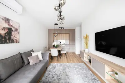 a living room with a couch and a flat screen tv at Žalia kopa Metropolis Vilnius in Vilnius
