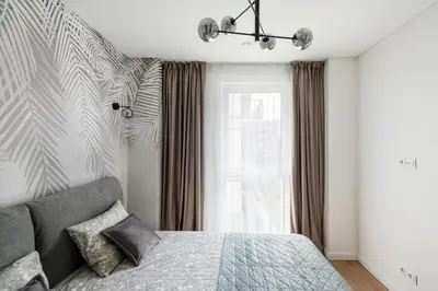 a bedroom with a bed and a window at Žalia kopa Metropolis Vilnius in Vilnius
