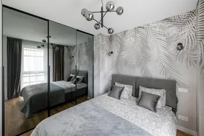 a bedroom with two beds and a mirrored wall at Žalia kopa Metropolis Vilnius in Vilnius