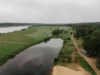 an aerial view of a river with a boat at Treehouse Virš Bedugnės in Jurbarkas