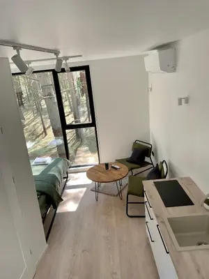 a living room with a table and chairs in a room at Treehouse Virš Bedugnės in Jurbarkas