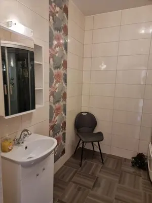 a bathroom with a sink and a chair in it at Druskininkai Algida in Druskininkai