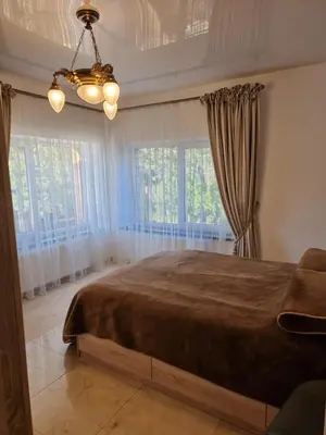 a bedroom with a large bed with curtains and a chandelier at Druskininkai Algida in Druskininkai