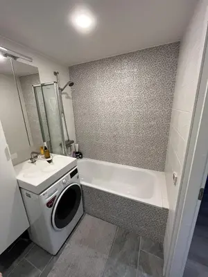 a bathroom with a tub and a washing machine at Lovely Flat with Great Central Location Vilnius in Vilnius
