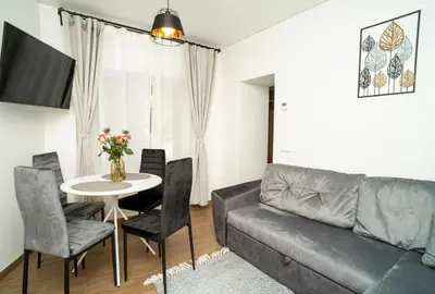 a living room with a couch and a table with chairs at Downhill Apartment on the Groundfloor in Kaunas
