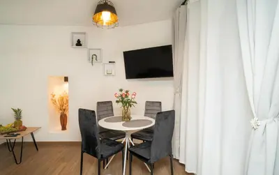 a living room with a table and chairs and a tv at Downhill Apartment on the Groundfloor in Kaunas