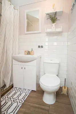 a white bathroom with a toilet and a sink at Downhill Apartment on the Groundfloor in Kaunas