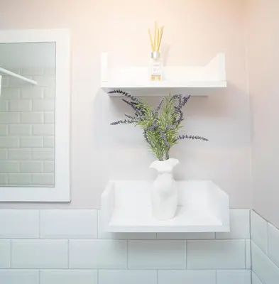 a white vase sitting on a shelf in a bathroom at Downhill Apartment on the Groundfloor in Kaunas