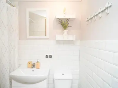 a white bathroom with a sink and a toilet at Downhill Apartment on the Groundfloor in Kaunas