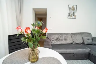a vase with flowers on a table in a living room at Downhill Apartment on the Groundfloor in Kaunas