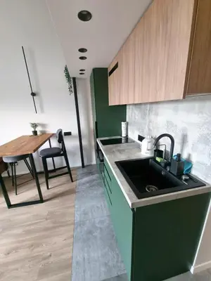 a kitchen with a sink and a dining table at Cozy Loft in Kaunas